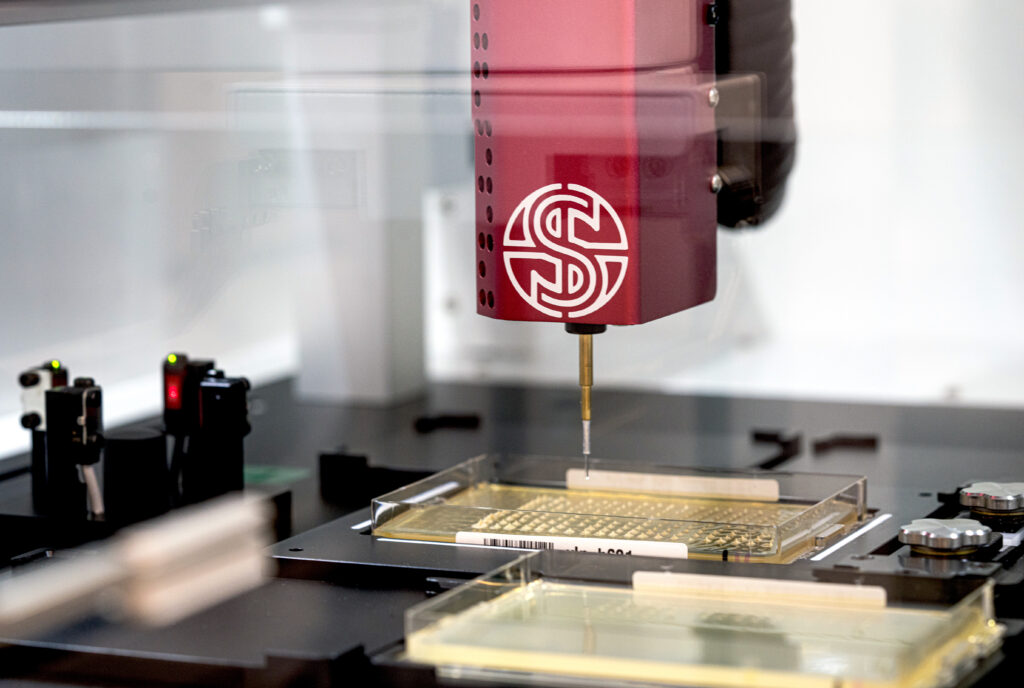 PIXL with a single picking head hovering above an SBS plate filled with an array of colonies