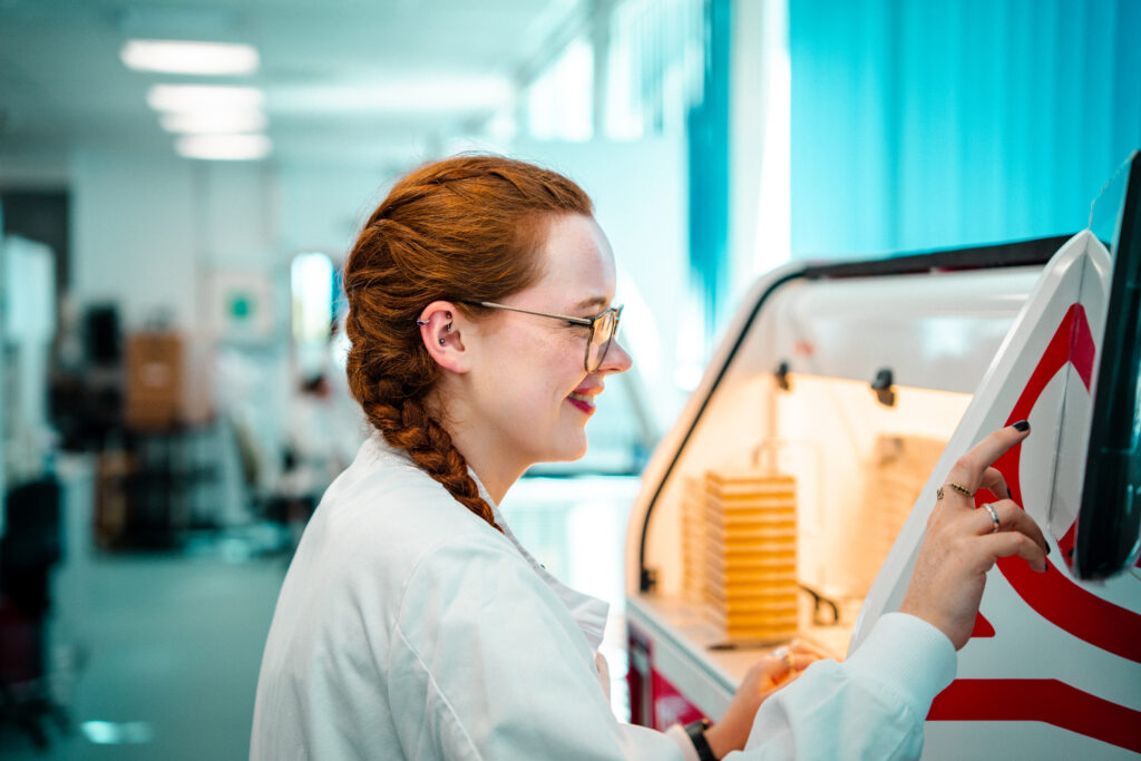 Catrin Williams faces the ROTOR+, a high-throughput screening robot, as she conducts an antifungal screen on it. 